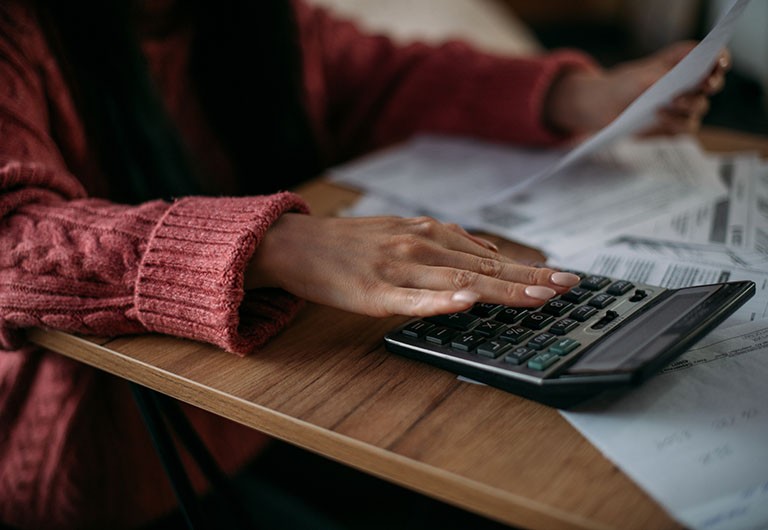 Woman calculates monthly household expenses