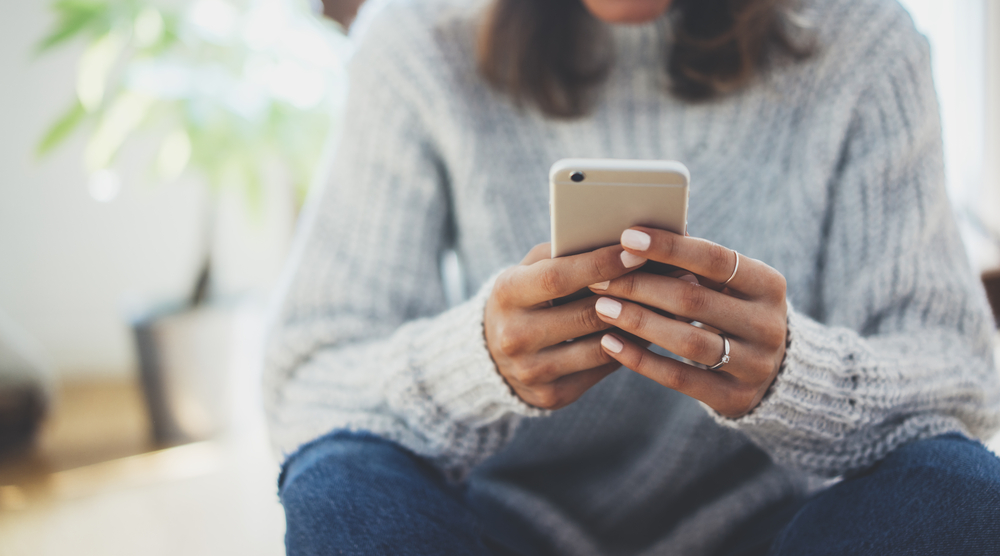 Seated woman looking at her mobile phone