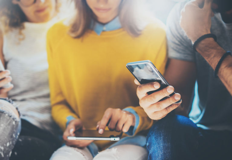 Gruppe junger Leute, die ihre Telefone überprüfen